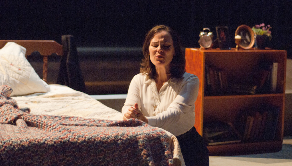 Sister Helen (played here by Elise Quagliata) prays for guidance, in the Des Moines Metro Opera production from 2014 prays for strength and for death-row inmate Joseph De Rocher to admit what he has done so he may clear his conscience before his execution during the Des Moines Metro Opera's production of Dead Man Walking.